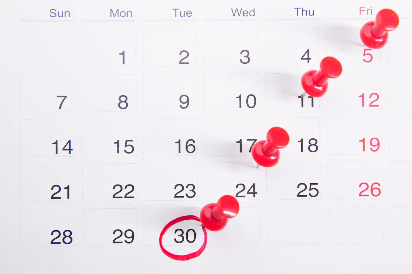 Calendar with red pins marking several dates