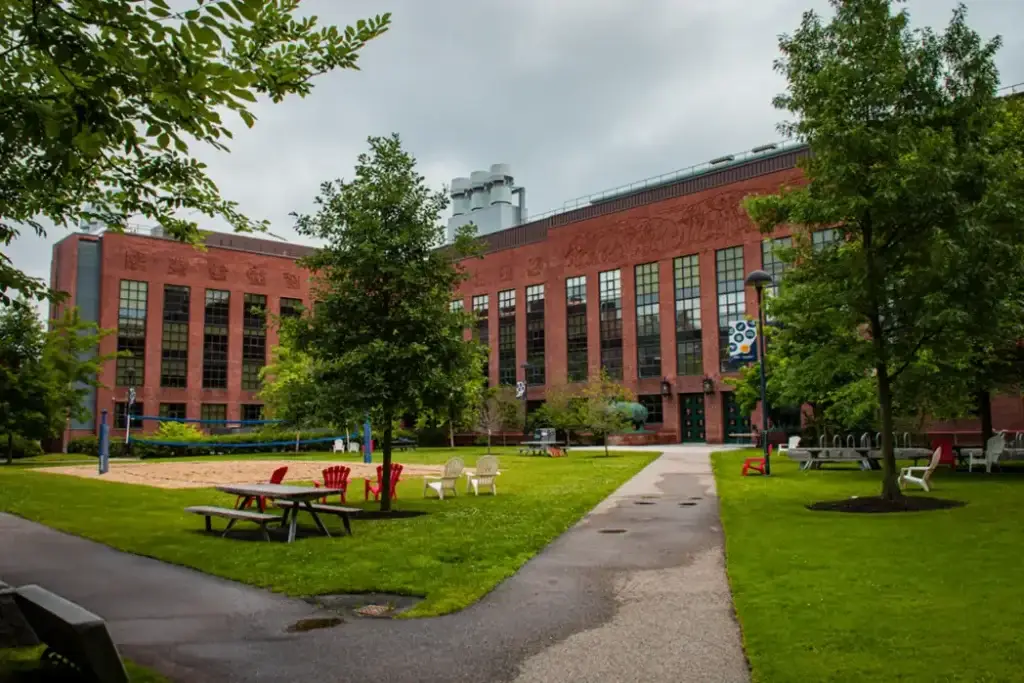 Green shared space beside a red-brick campus building