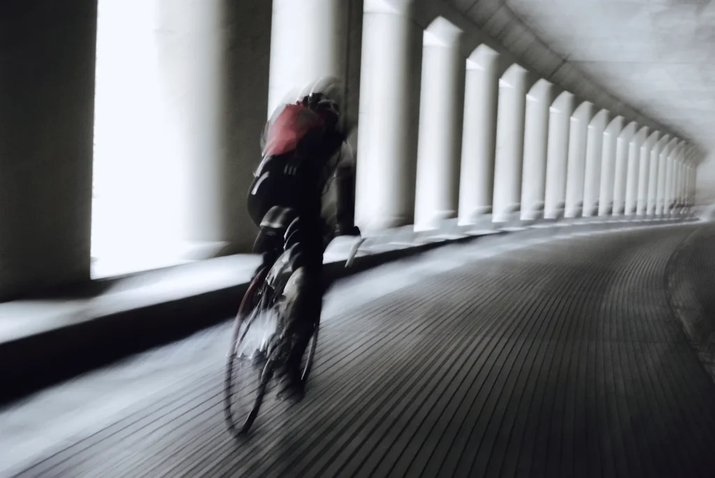 Cyclist moving through a covered colonnade