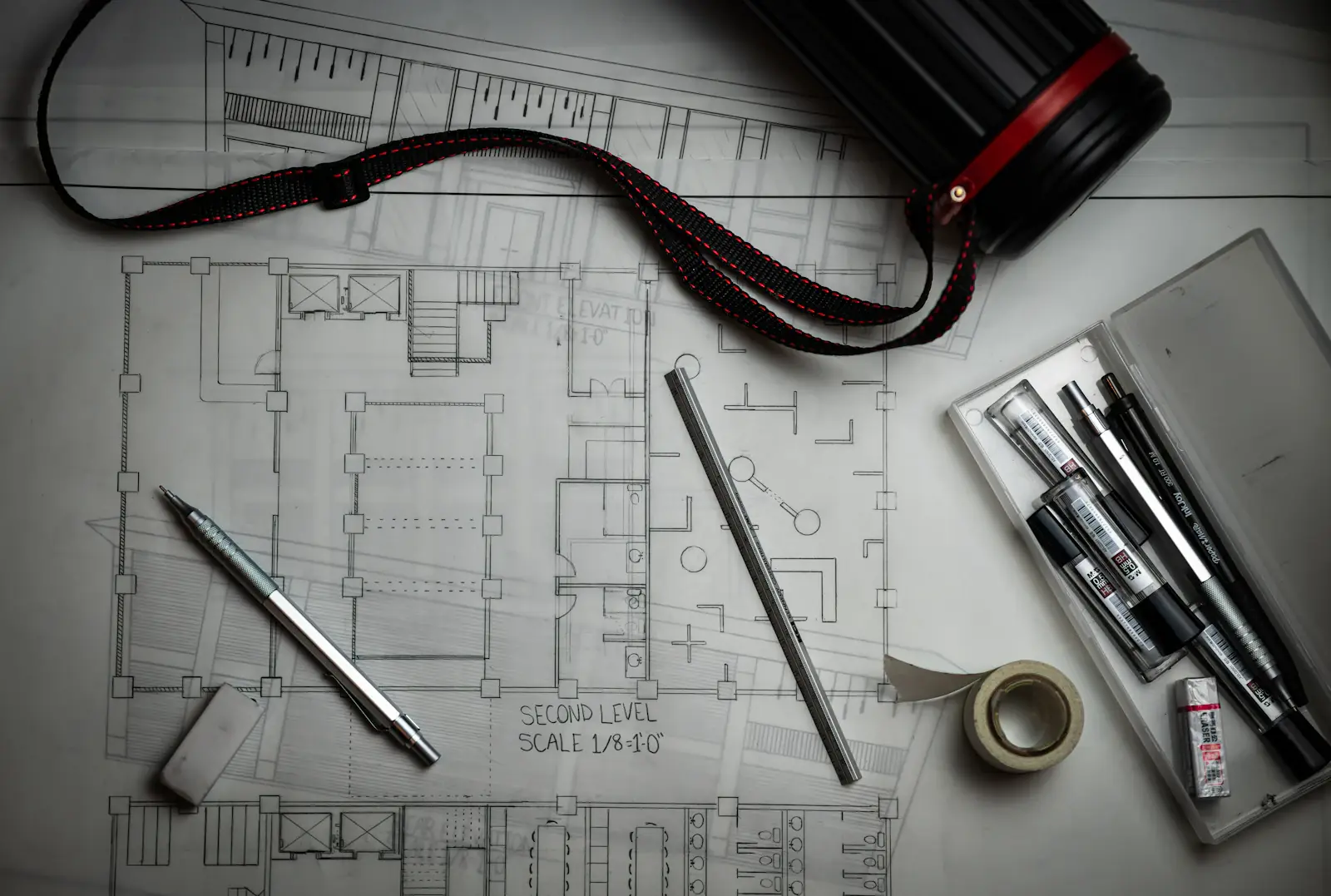 Architectural plans and drawing tools on a desk