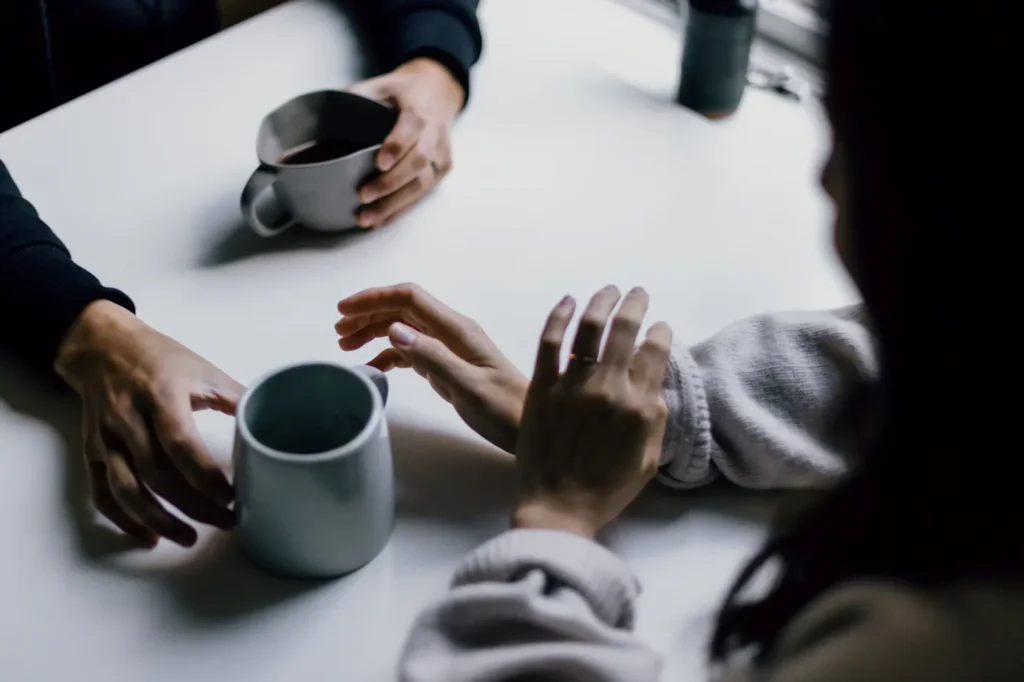 Hands and coffee cups around a shared table