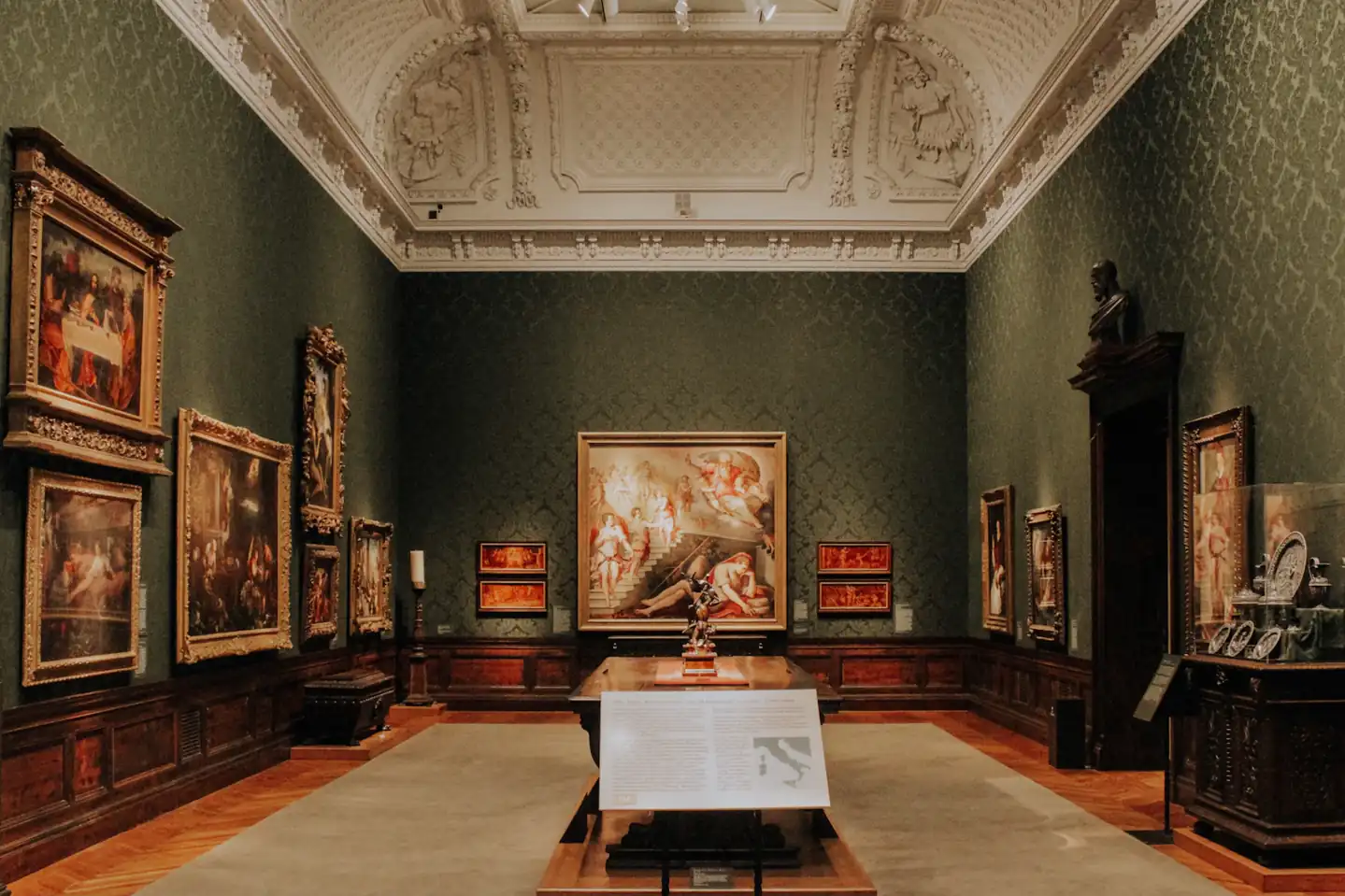 Paintings arranged inside a high-ceilinged museum gallery