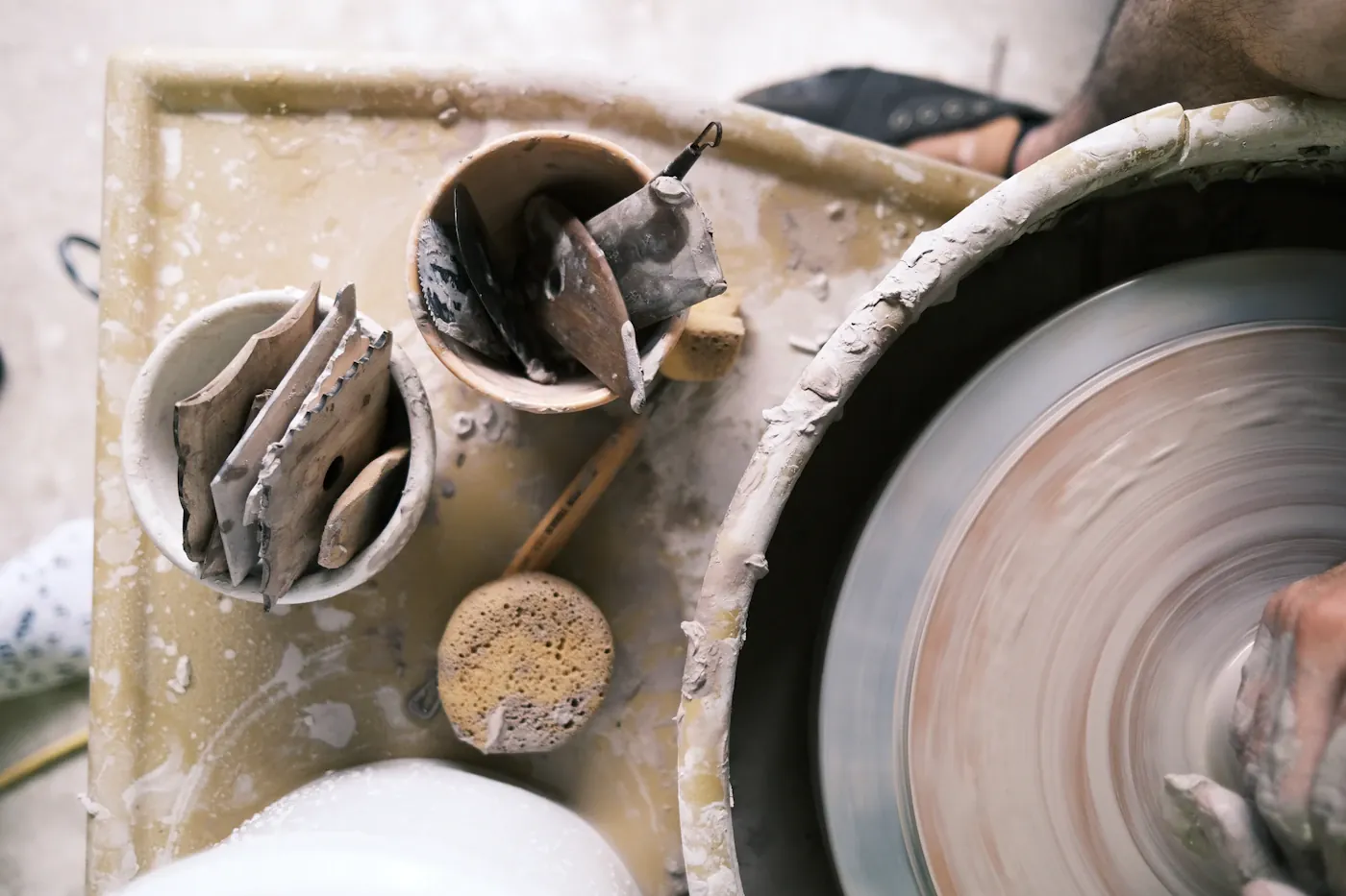 Clay vessels and tools beside a pottery wheel