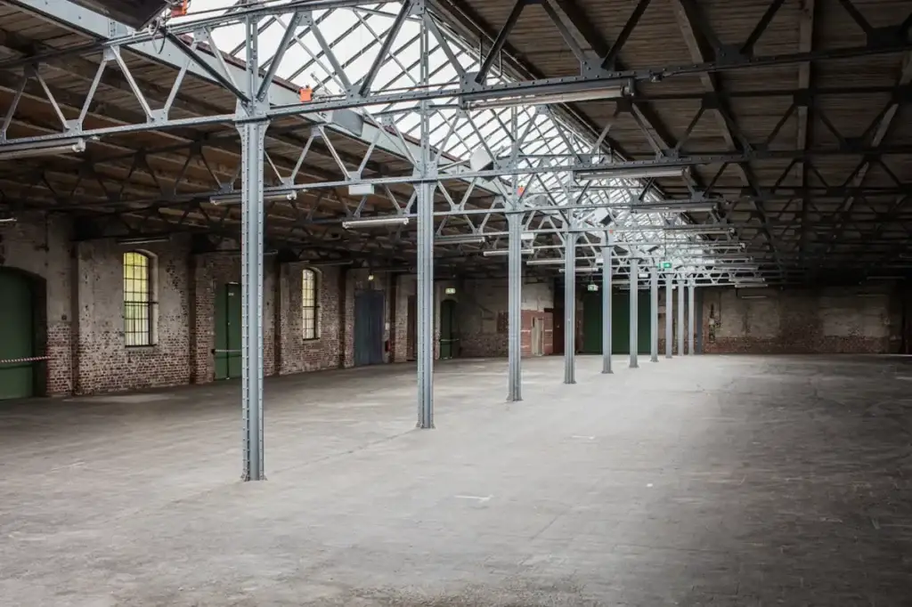 Large industrial interior with beams and brickwork