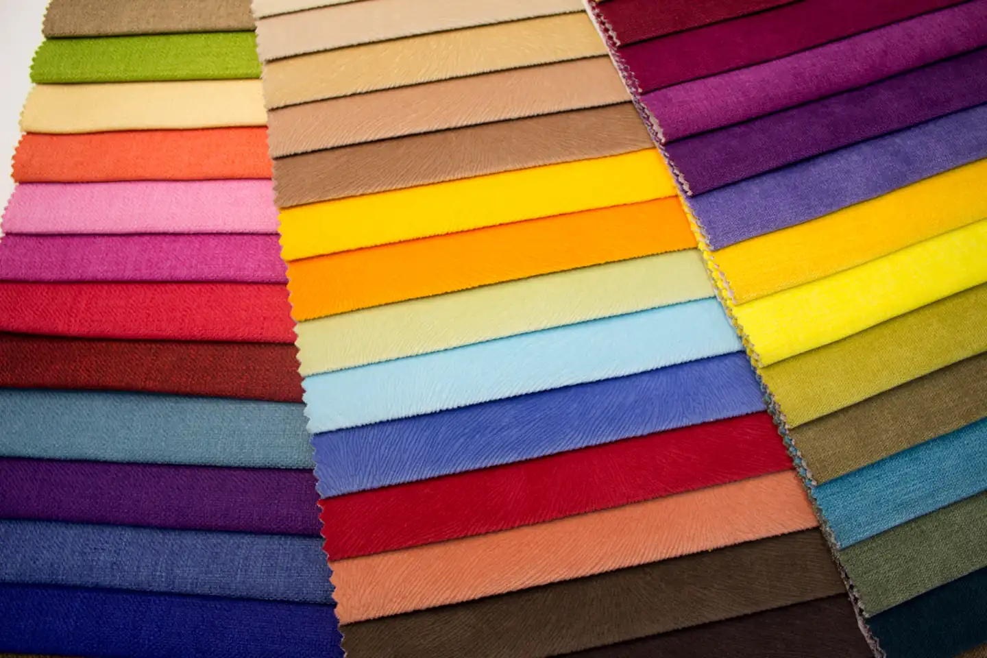 Folded fabrics arranged in a range of colours