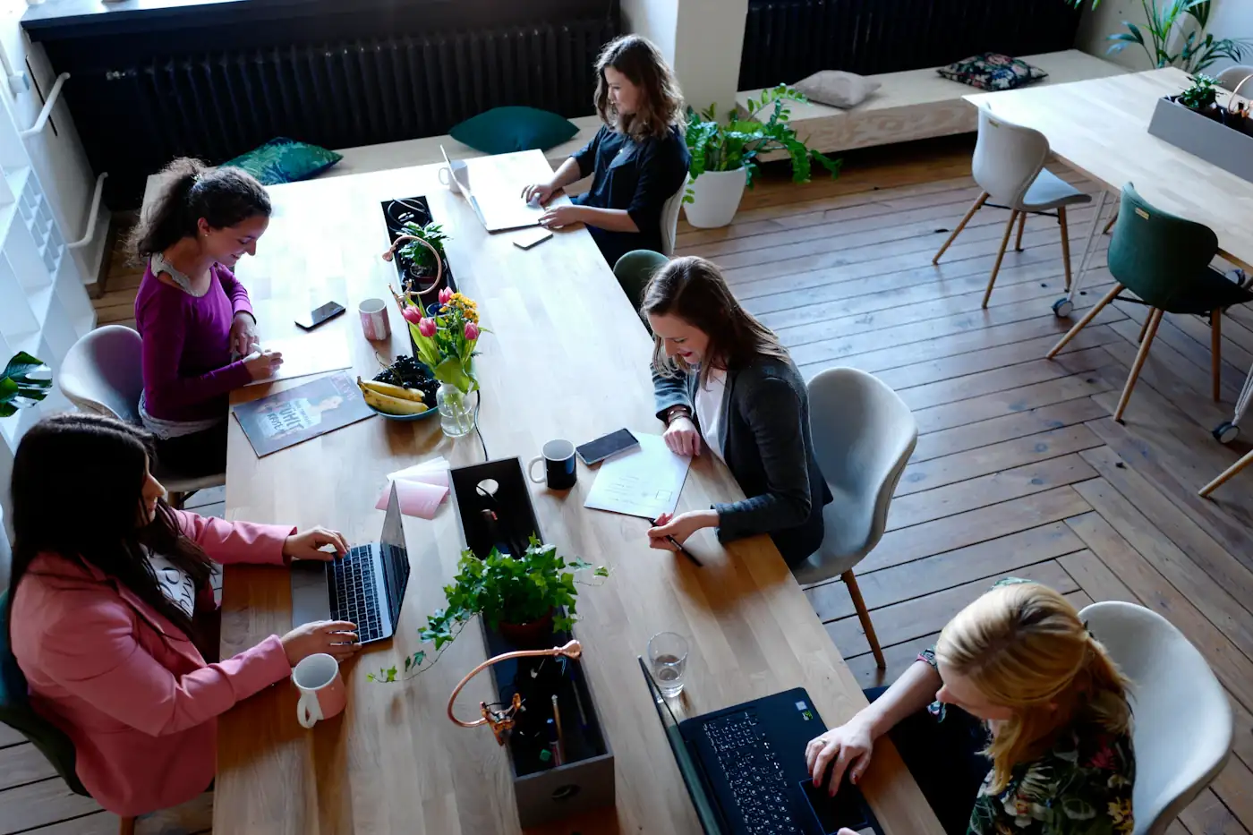 Colleagues working around a shared wooden table
