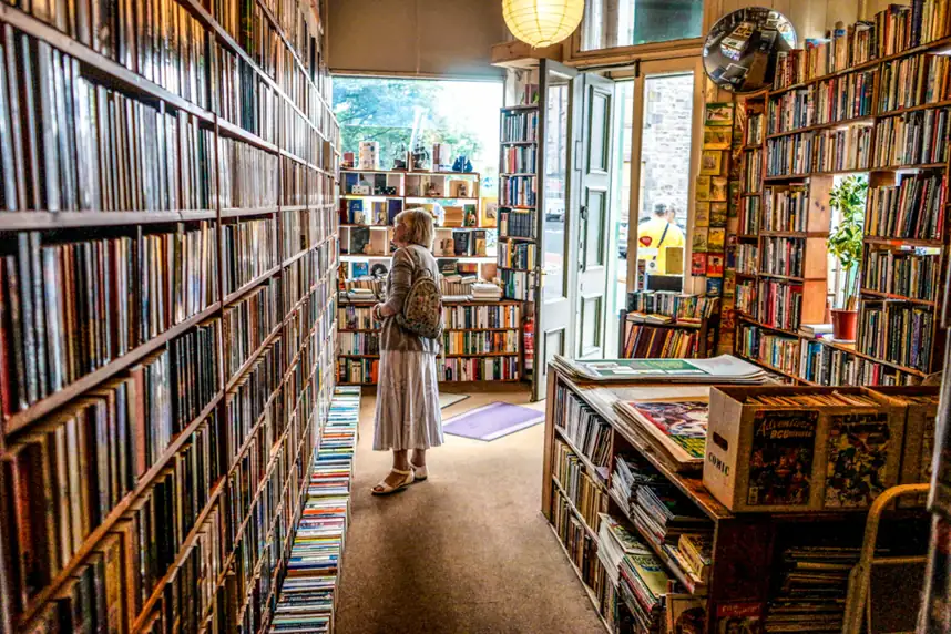 Narrow bookshop aisle lined with books