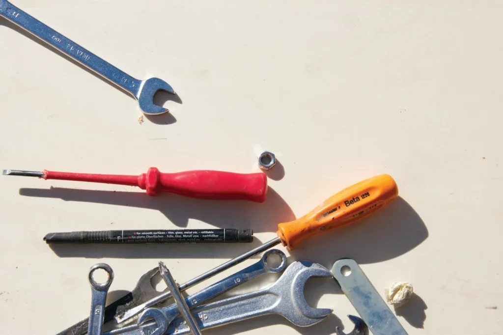 Wrenches and screwdrivers arranged on a light surface