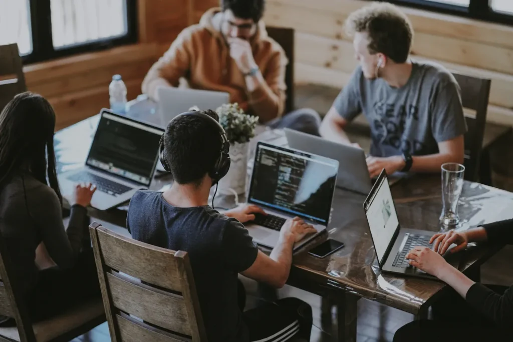 Small team discussing work around laptops