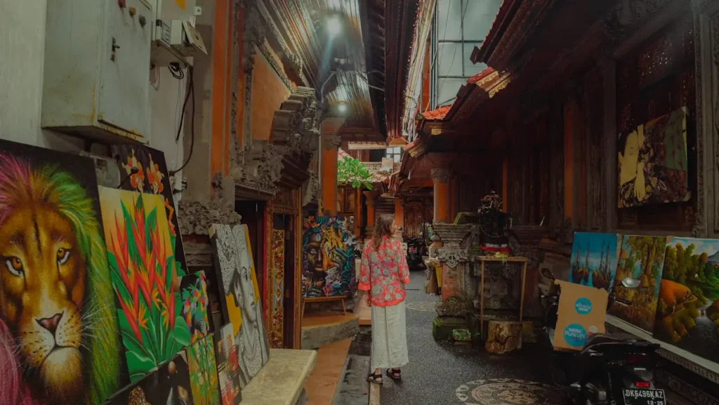 Paintings displayed along a narrow pedestrian alley